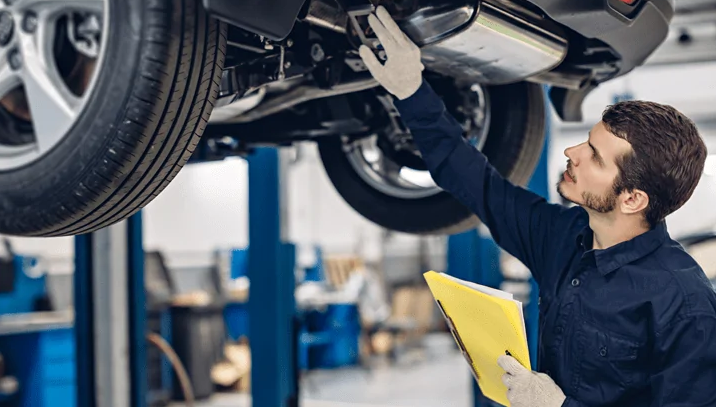 A mechanic with a clipboard inspecting the suspension