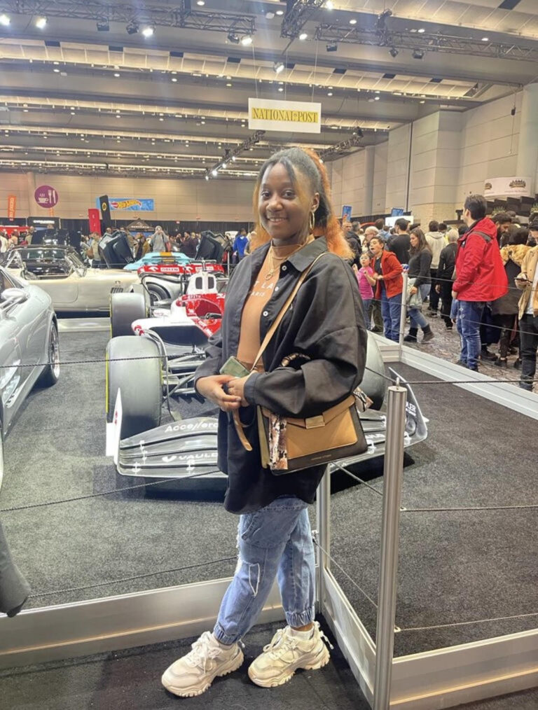 Deidra Clarke posing with an F1 car