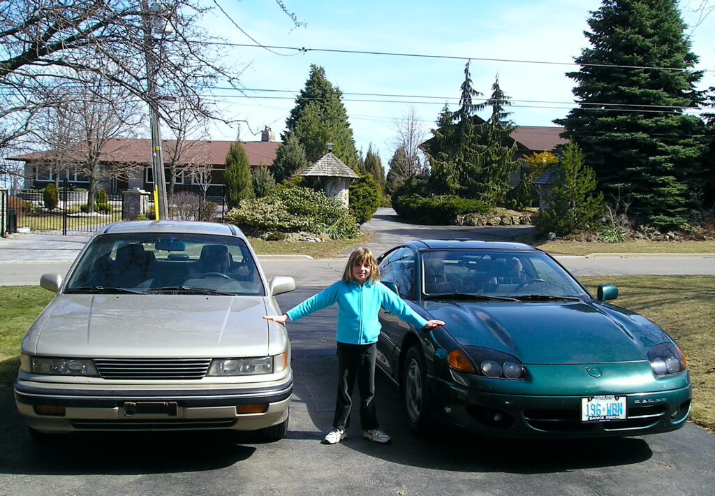 Mark Toljagic's Daughter Poses In Between A Rare Dodge 2000 Gtx And Dodge Stealth Coupe