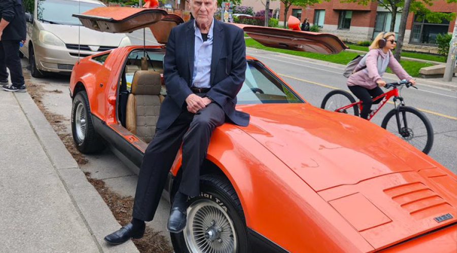 Malcolm Bricklin sitting on a Bricklin SV1